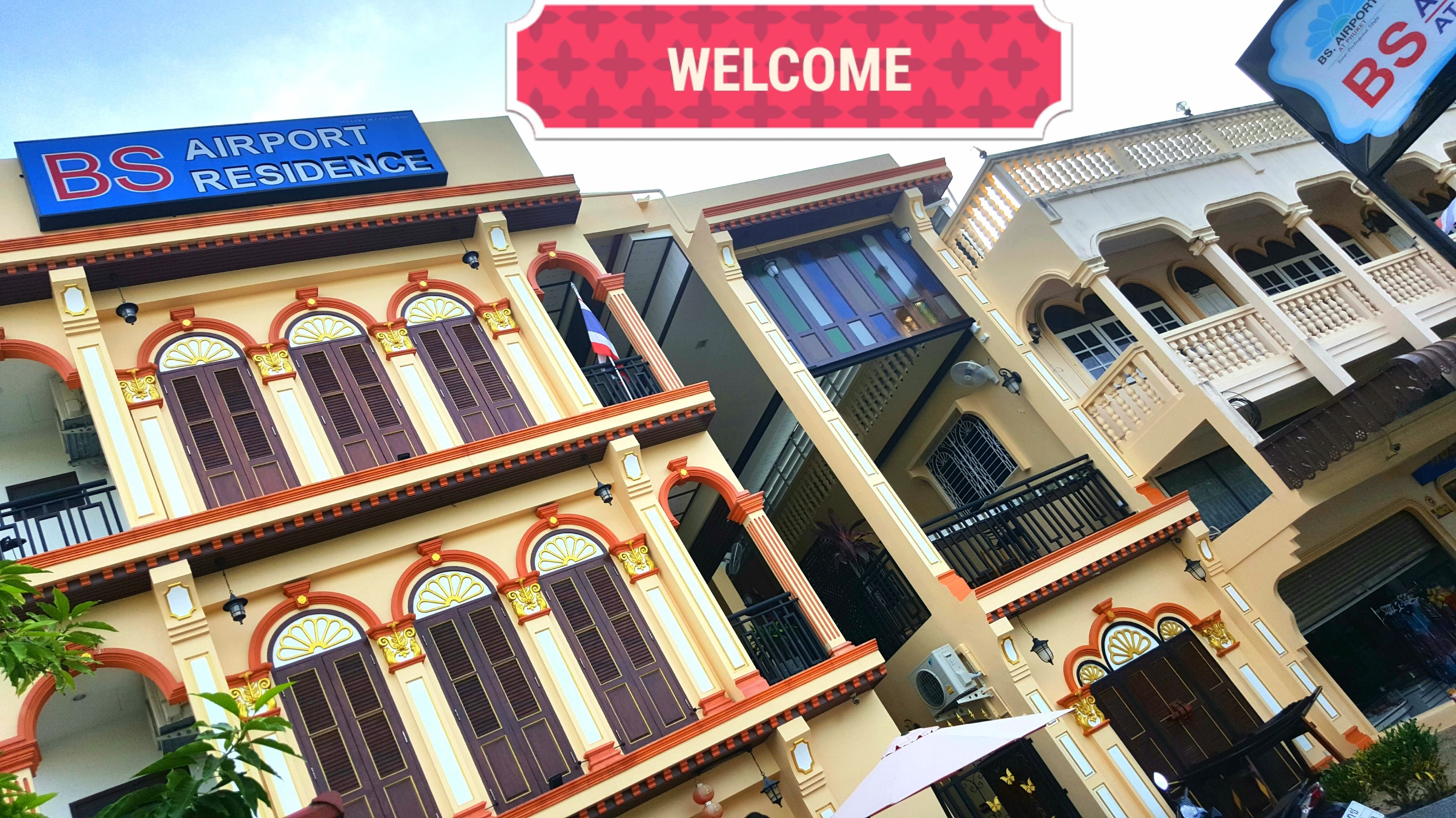 A building with a 'BS AIRPORT RESIDENCE' sign, traditional architectural style with multiple balconies and arched windows.