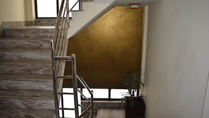 Una escalera con escalones de mármol y una pared dorada.