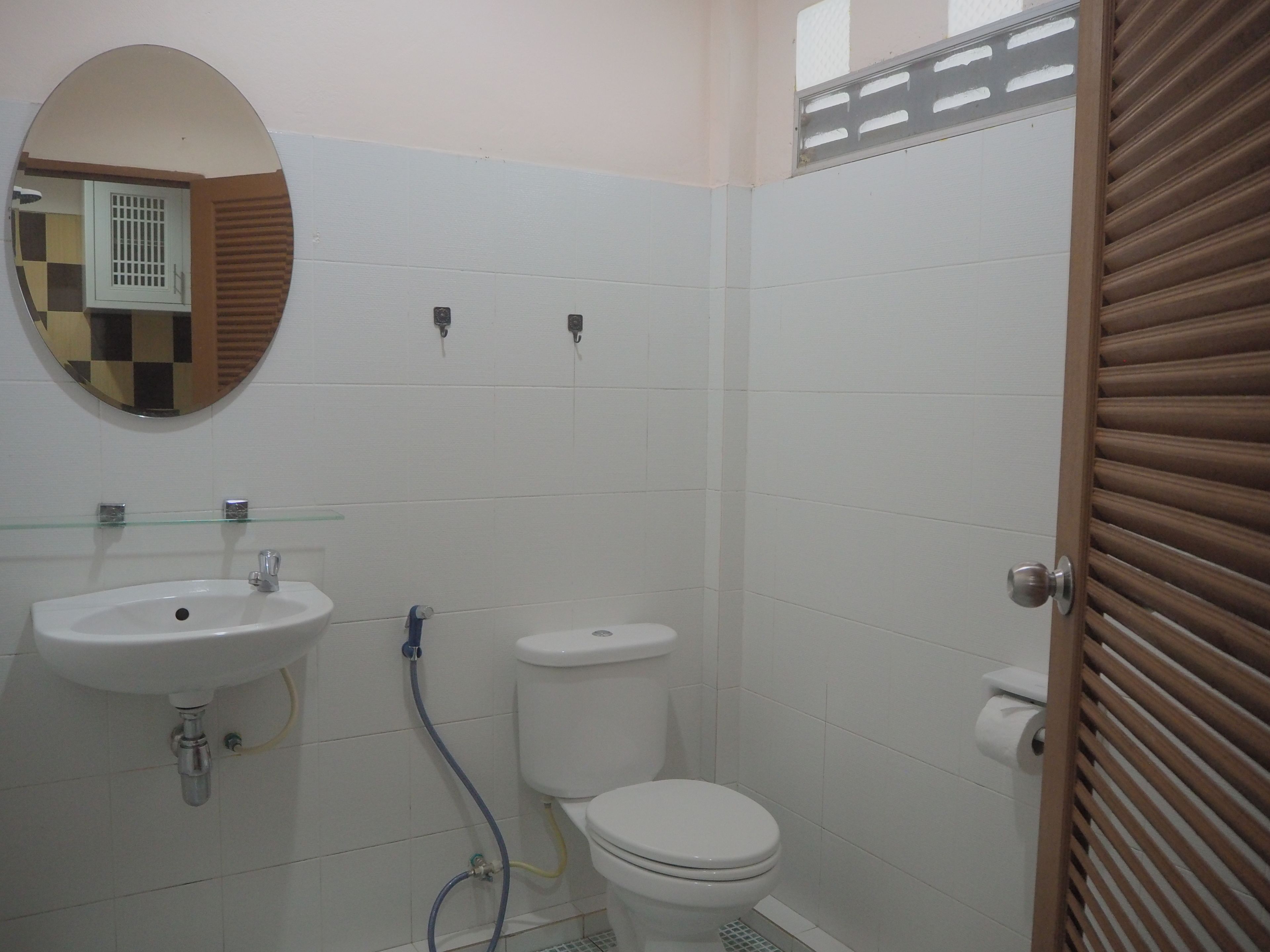 Un baño con lavamanos, inodoro y espejo.