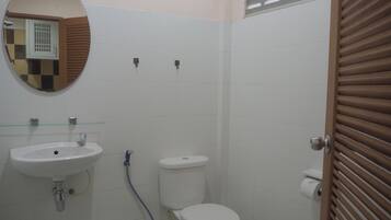 Un baño con lavamanos, inodoro y espejo.