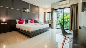 Una habitación de hotel moderna con una cama grande, un escritorio y un balcón con vistas.
