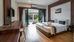 Habitación de hotel moderna con una cama grande, un escritorio y vistas a una piscina y un edificio a través de puertas de vidrio.