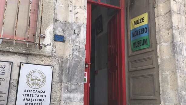 Entrada d'un edifici amb una porta vermella i un rètol per al MUSEU MÜZE MOYEIO.