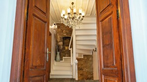 A wooden door leading to a staircase with a chandelier. - Katina Bozcaada (Bozcaada)