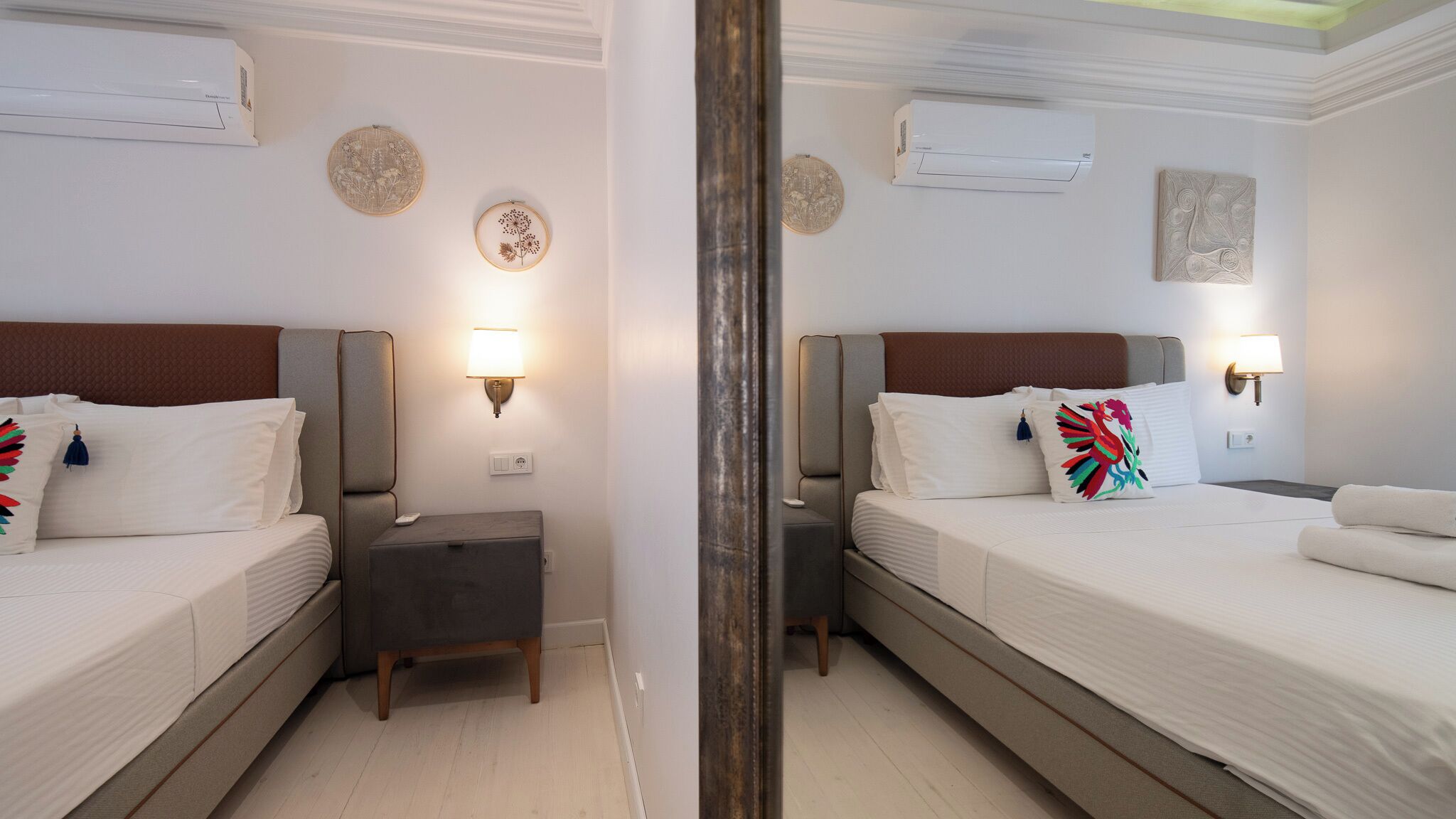 Una habitación de hotel con dos camas, lámparas de noche y decoración en la pared.