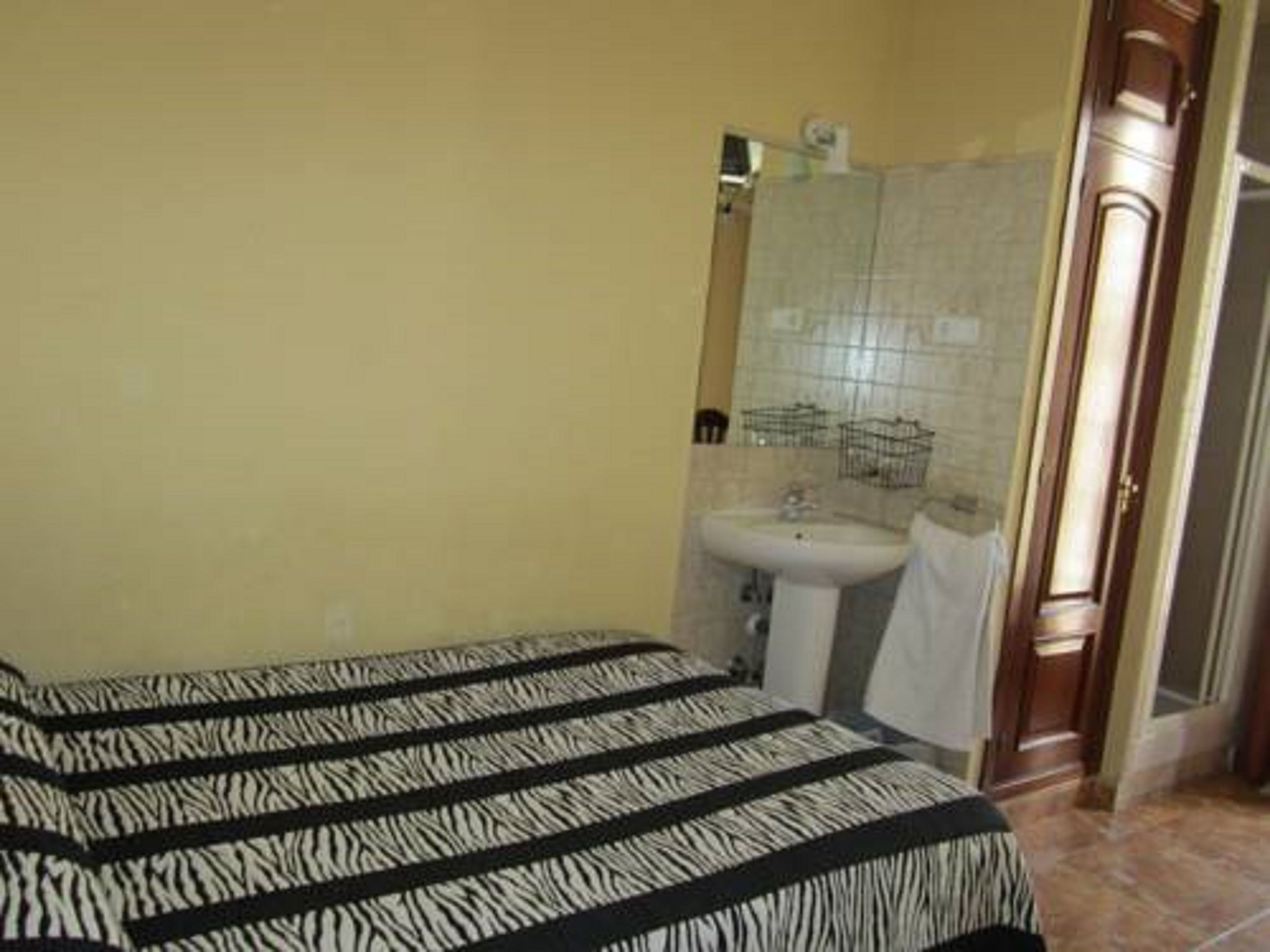 Een badkamer met een wastafel, spiegel en handdoekrek.