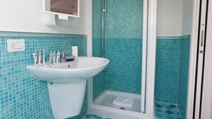 A bathroom with a sink, mirror, and shower. - Italianway   - Alessi (Milan)
