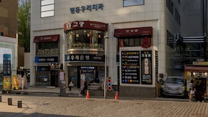 Un immeuble à plusieurs étages, sur lequel on peut voir un grand panneau lumineux avec l'inscription « Sunshine ».