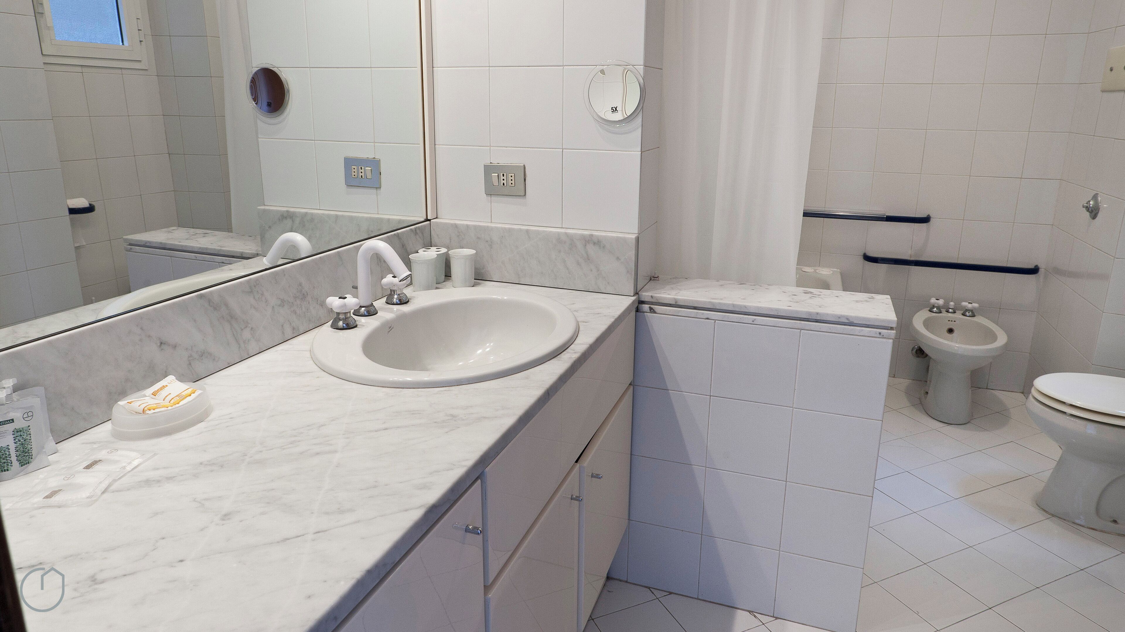 A modern bathroom with a marble sink, a toilet, and a bidet.