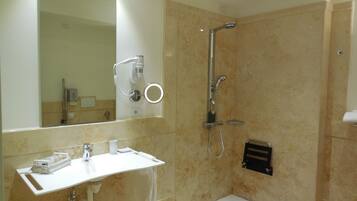 Une salle de bain avec un lavabo, un miroir et une douche.