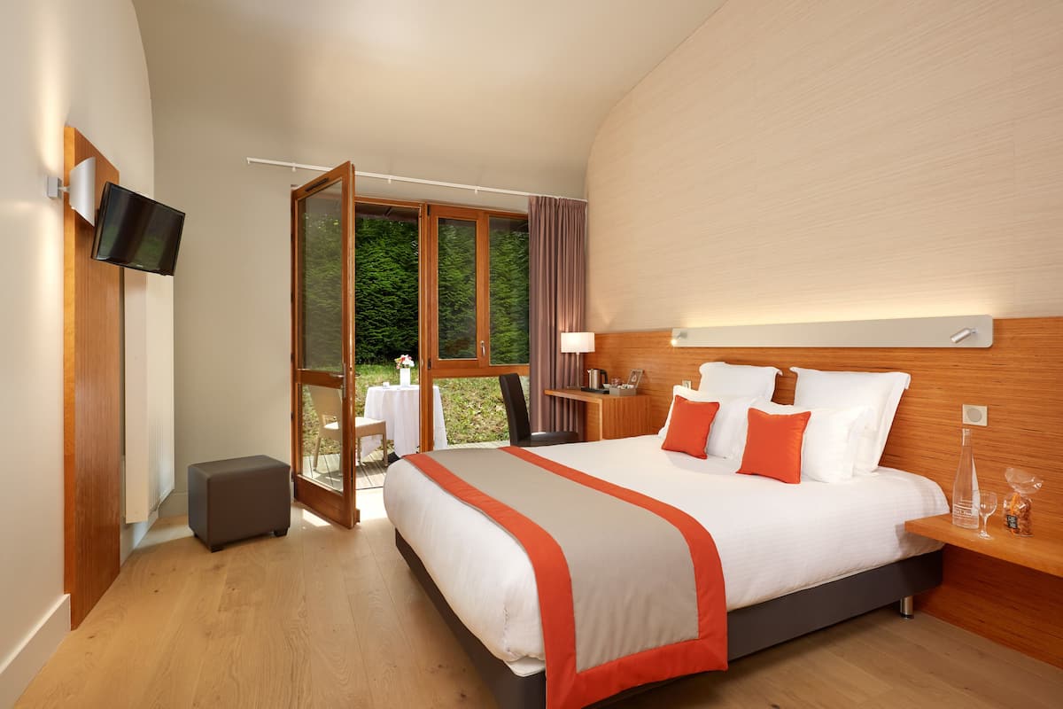 Une chambre d’hôtel moderne, dotée d’un grand lit, d’un bureau et d’une télévision.