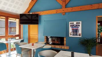 Una habitación con chimenea, televisor montado y camiseta de ciclismo enmarcada en la pared.