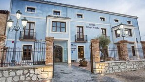 Un edificio de dos pisos con un letrero que dice "HOTEL Laager de Bell". Cuenta con fachada de piedra, múltiples ventanas y una entrada con reja.