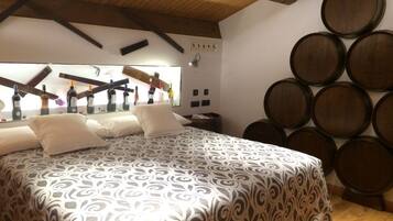 Een slaapkamer met een bedovertrek met patroon, houten balken in het plafond en een muur met wijnvaten.