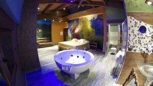 Un baño lujoso con una amplia bañera independiente, un espacio tipo spa y un dormitorio con una cama grande y un mural en la pared.