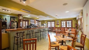 Un restaurant doté d’un bar, de chaises et de tables en bois.