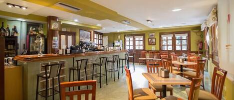 Un restaurante con barra, sillas y mesas de madera.