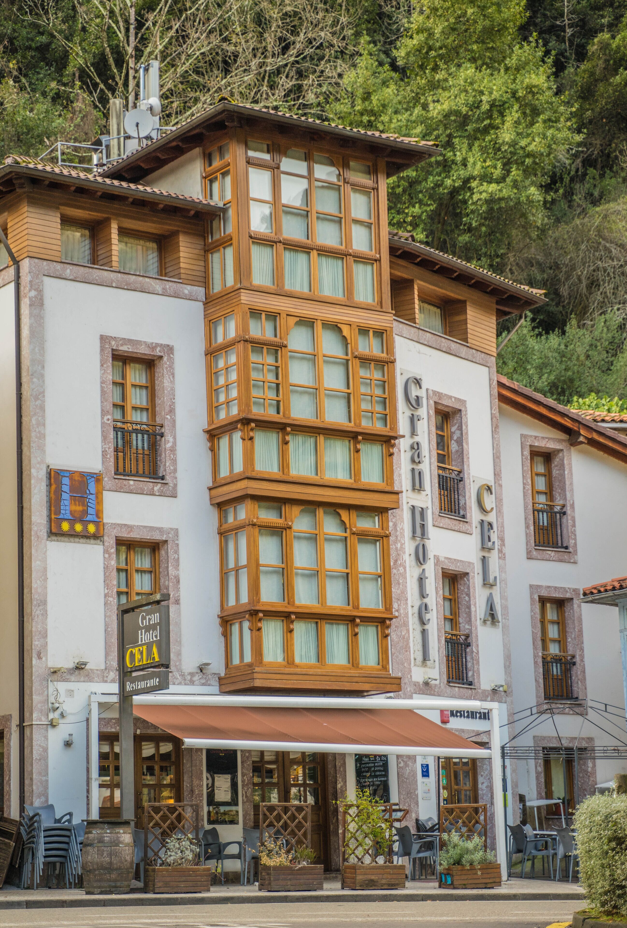 Un hotel con una torre en esquina, grandes ventanales y un balcón. La fachada muestra el rótulo del hotel y del restaurante.
