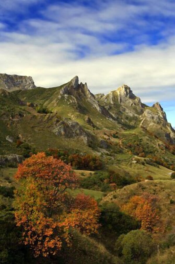 A mountainous landscape with autumn foliage and rocky terrain.