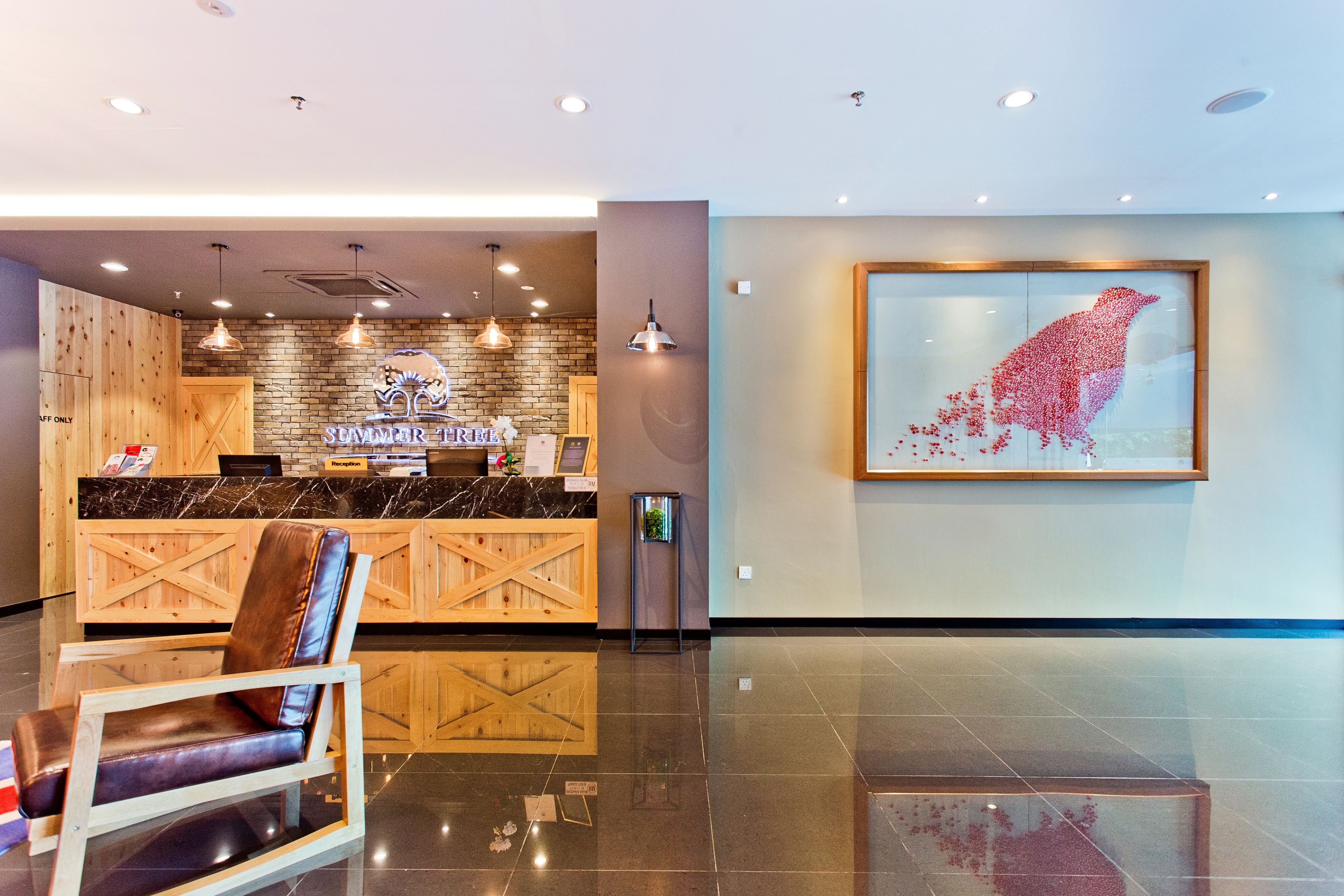 A reception area with a wooden counter, a framed artwork, and a seating area.