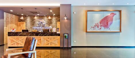 A reception area with a wooden counter, a framed artwork, and a seating area.