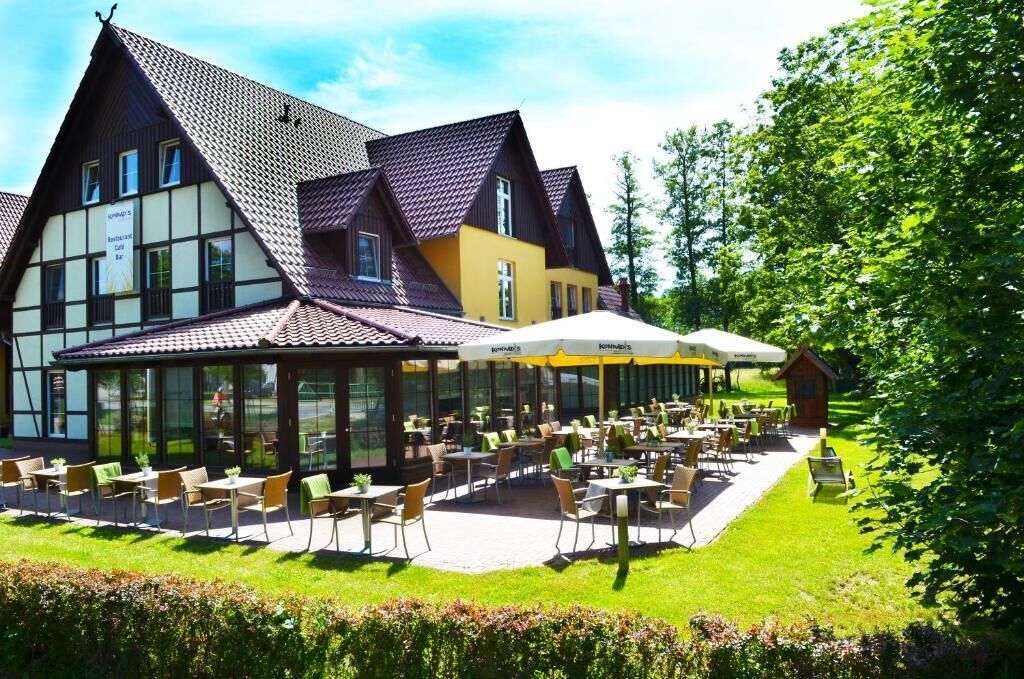 A building with a restaurant patio, outdoor seating, and a garden area.