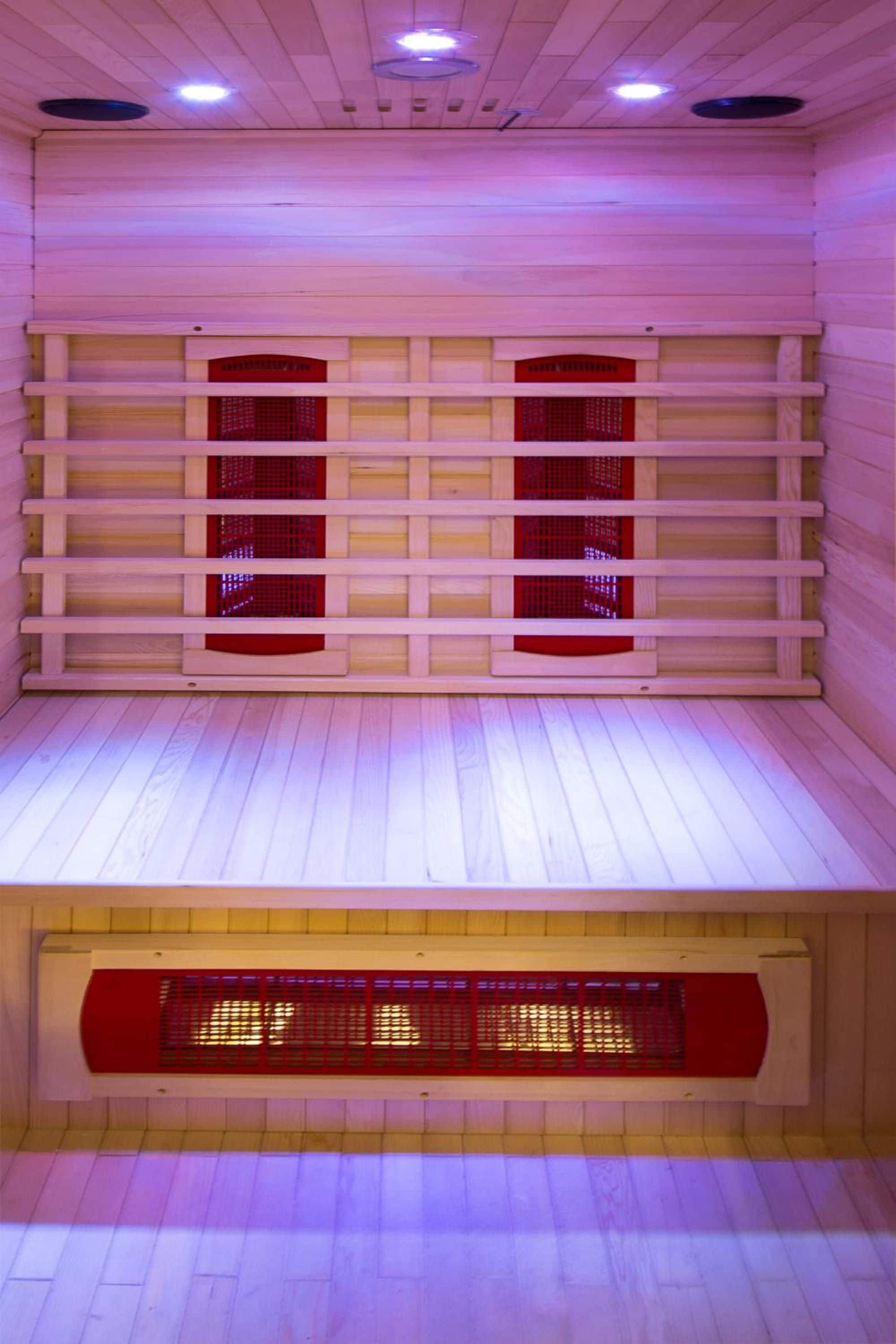 A sauna room with wooden walls, a sloped ceiling, and a floor.