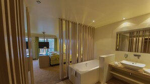 A modern bathroom with a freestanding bathtub, a large mirror, and a vanity with a sink.