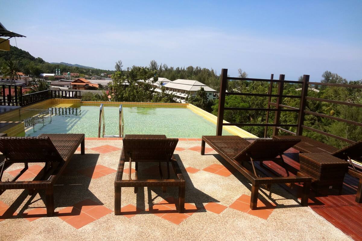 A poolside area with lounge chairs and a view of a pool.