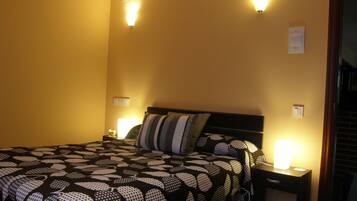 A hotel room with a bed, two bedside lamps, and a nightstand.