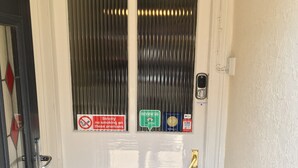A white door with a no-smoking sign, a review card, and a payment card reader.