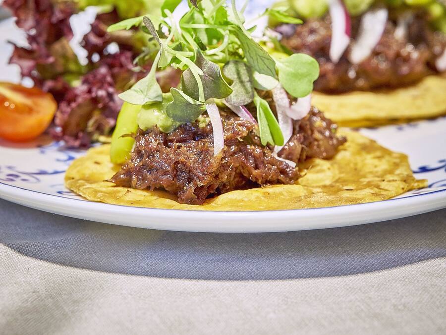 Un plato de tacos con verduras frescas y una ensalada al lado.