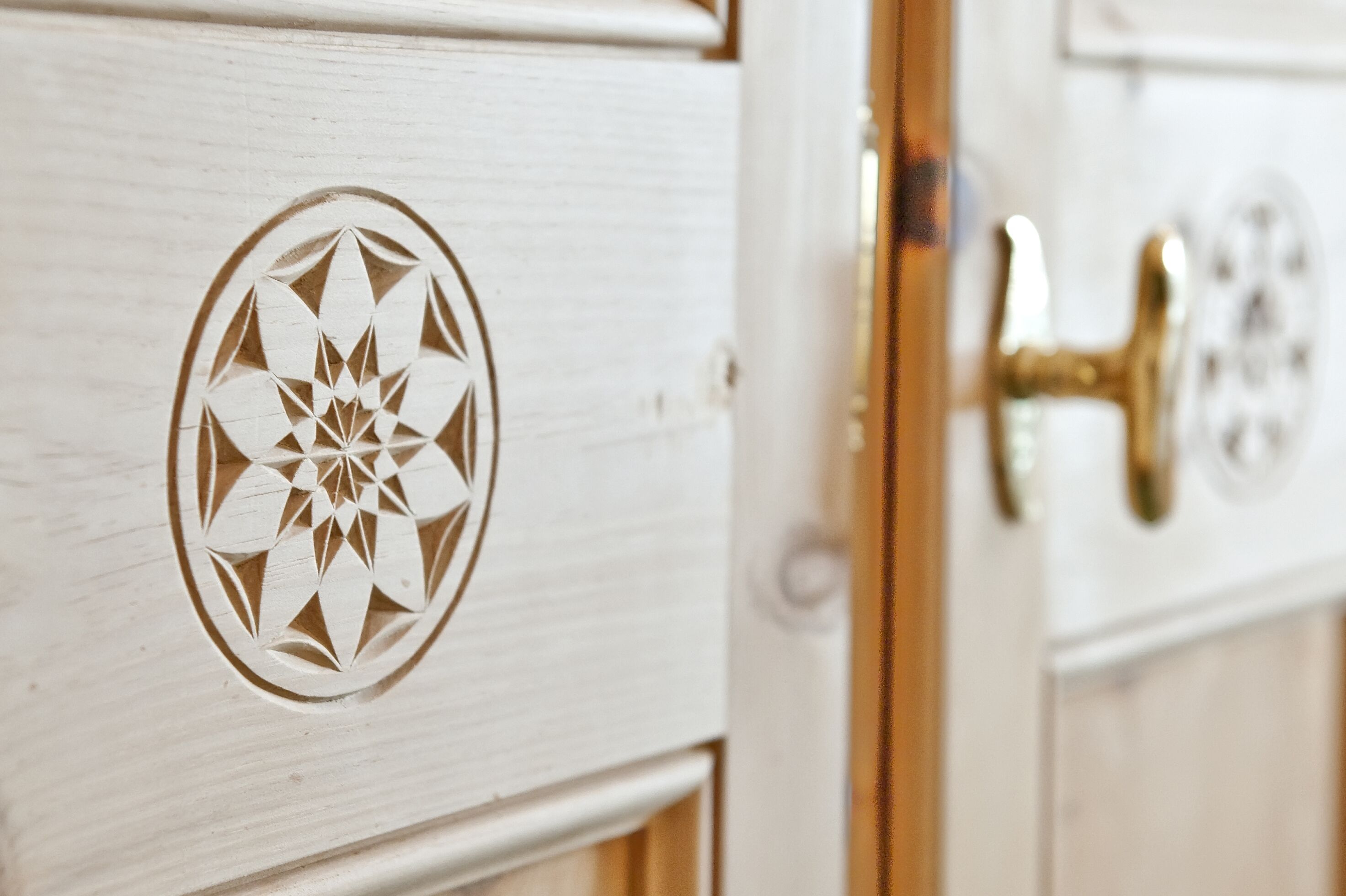 A wooden door with a geometric pattern and a brass handle.