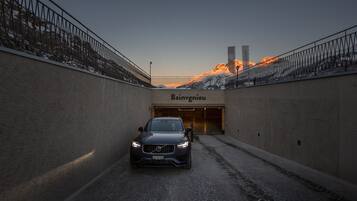 Un coche estacionado en un túnel, con una montaña al fondo.