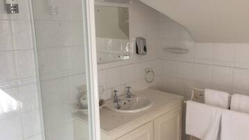 A bathroom with a white sink, mirror, and towel rack.