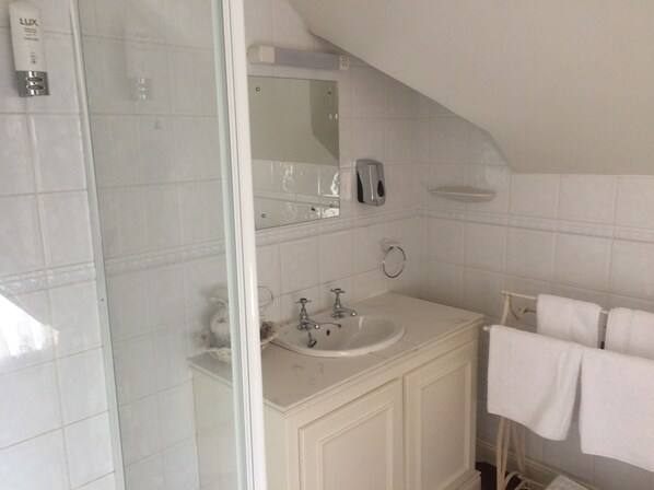 A bathroom with a white sink, mirror, and towel rack.