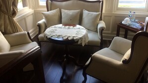 A cozy room with a classic armchair and a small round table with a lace tablecloth.