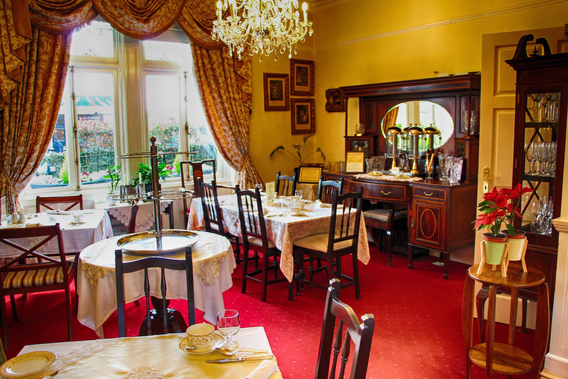 Un espace repas avec des tables rondes, des chaises et un lustre.