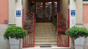 A hotel entrance with a reception desk, double doors, and steps leading up to it. - Hotel Vila da Guarda (A Guarda)