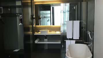 Un baño moderno con bañera, lavamanos y espejo.