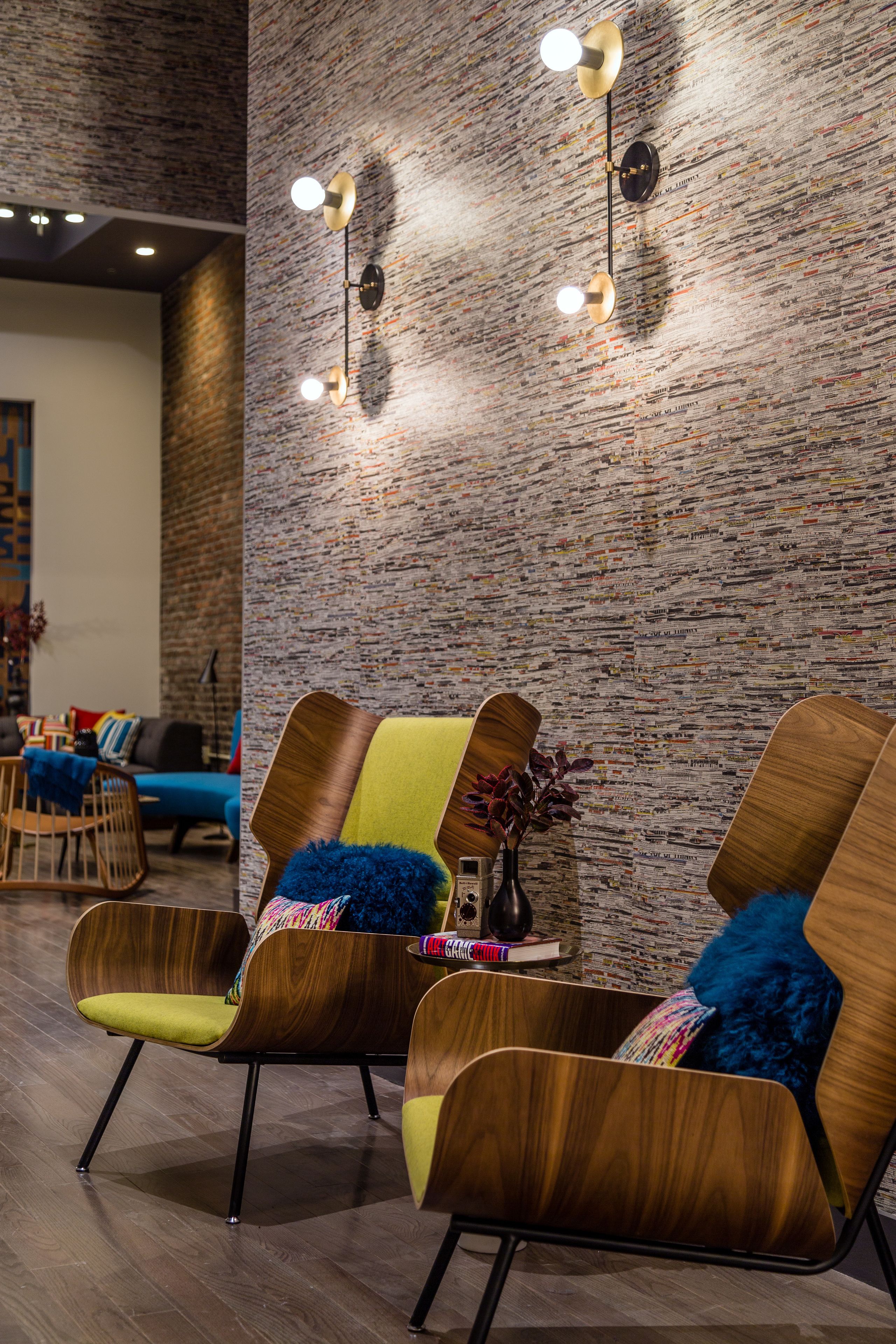 A modern interior with wooden chairs and a brick wall.