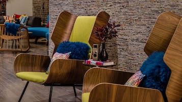 A modern interior with wooden chairs and a brick wall.