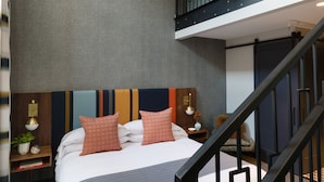 A modern hotel room with a large bed, a balcony, and a staircase. - The Hotel Salem (Salem)