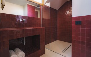 A modern bathroom with a glass shower enclosure, a built-in bathtub, and a towel rack.