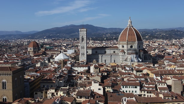 A panoramic view of a cityscape with prominent historical architecture, including a cathedral with a large dome and a bell tower. - c-hotels Joy (Florence)