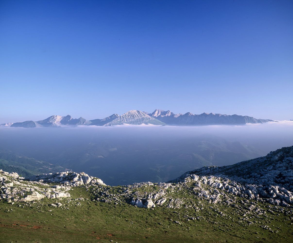 A mountainous landscape with snow-covered peaks and a valley below.