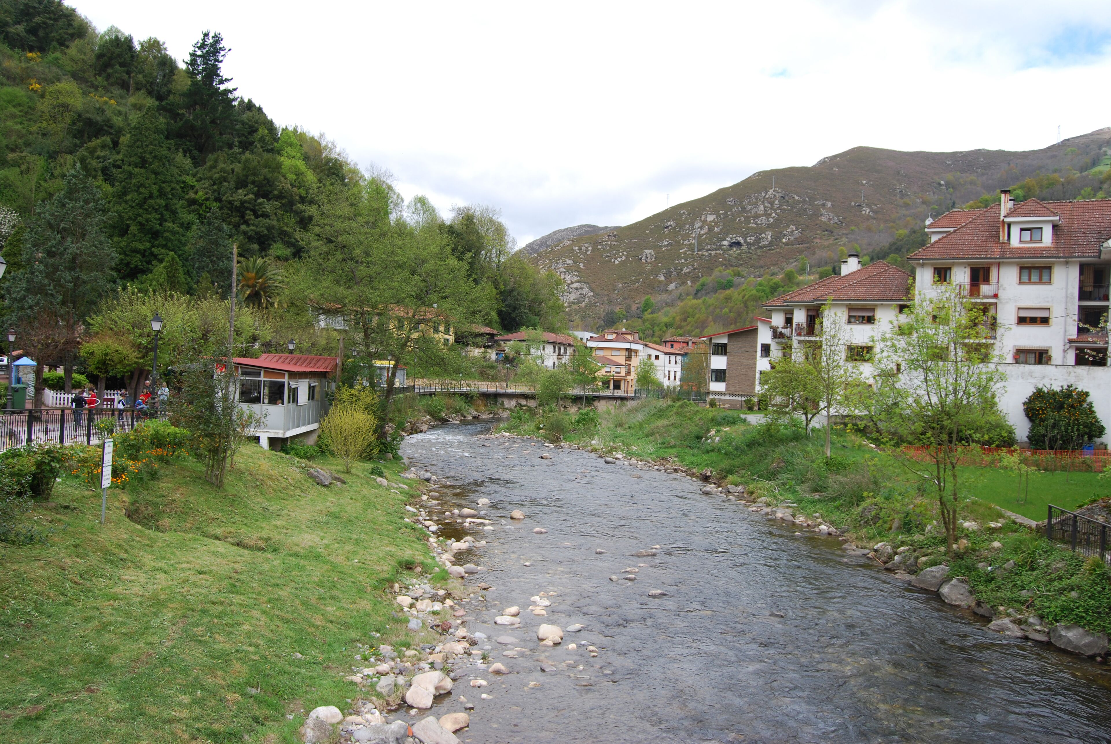 A river flowing through a residential area with houses on both sides.