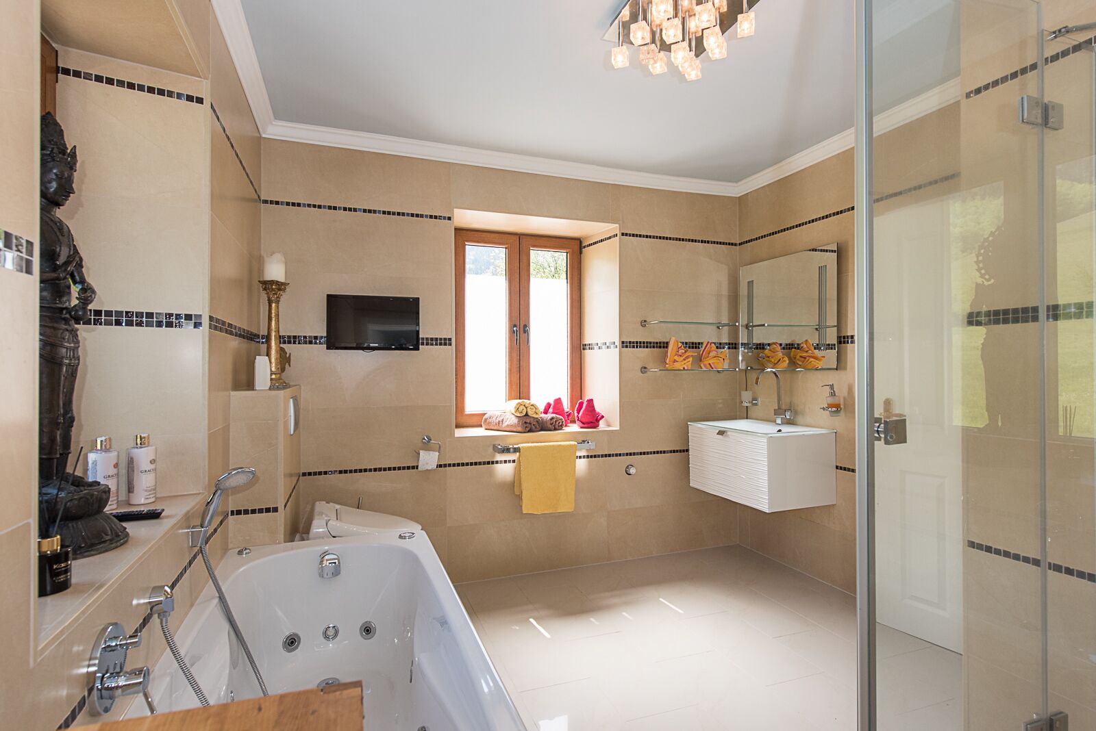 Un baño moderno con bañera, tocador con espejo y zona de ducha.