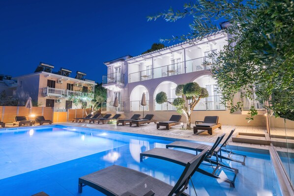 Una piscina al aire libre de temporada, sombrillas