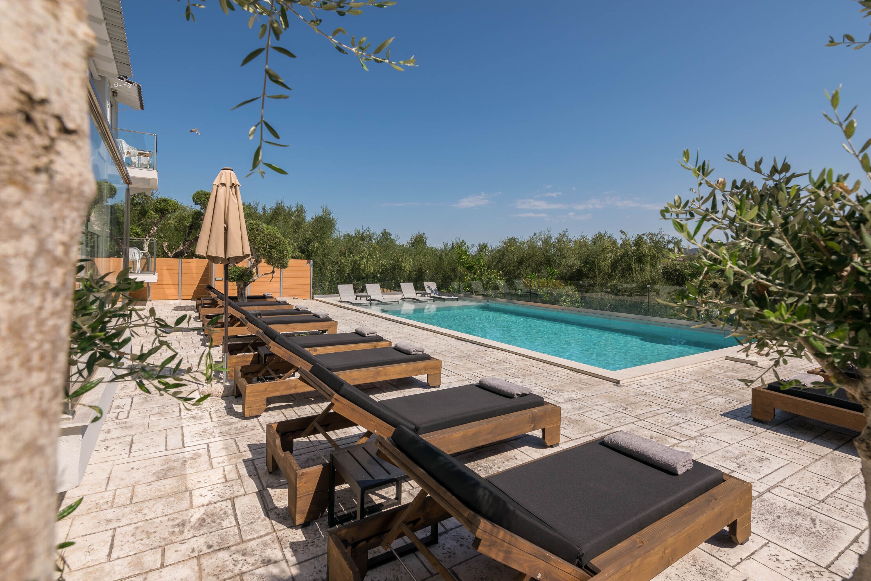 A poolside area with wooden loungers and a pool.